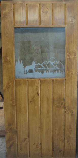 Etched wood door with wolf and trees