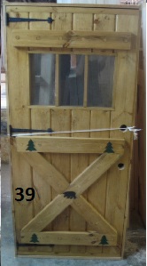 Exterior stockade door witth crossbuck with rustic carvings and 3 lite window